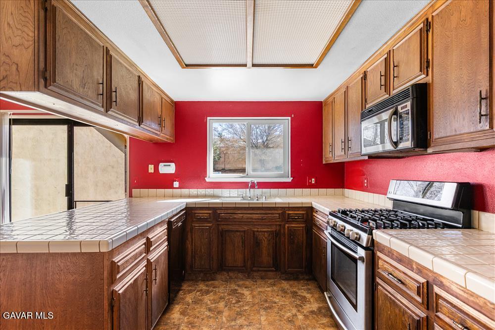 114 Chaparrel Street Tehachapi, CA 93561 - Photo 11 of 31 a kitchen with stainless steel appliances granite countertop a stove sink and cabinets