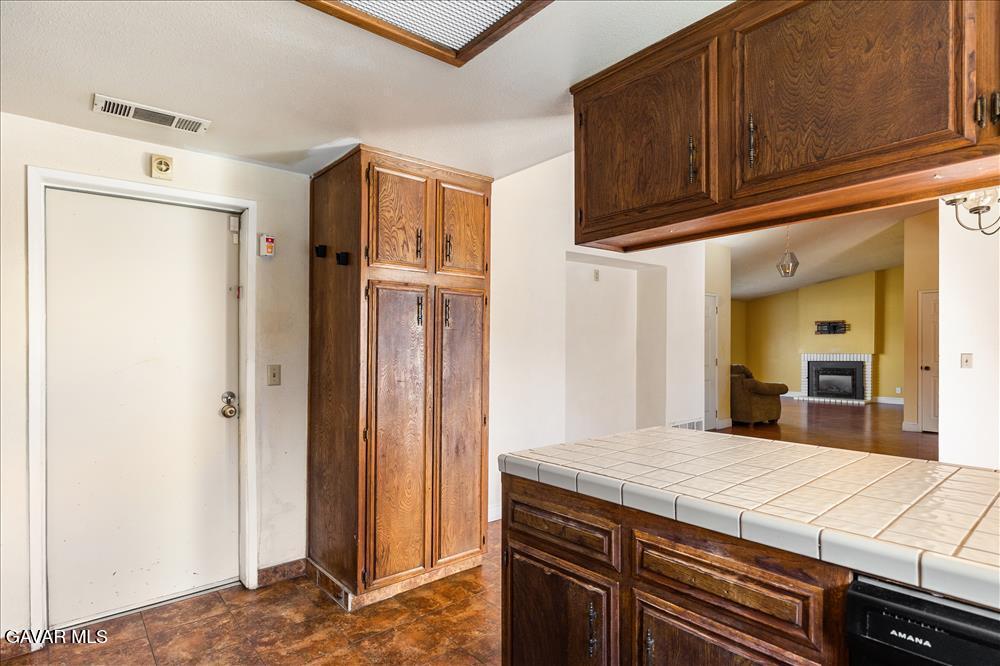 114 Chaparrel Street Tehachapi, CA 93561 - Photo 12 of 31 a kitchen with granite countertop a refrigerator and a stove top oven