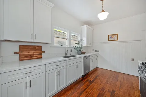a bedroom with a bed and a dresser next to a window