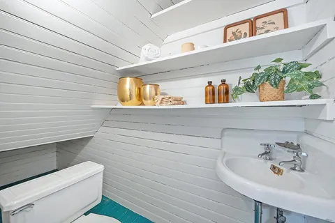 a bathroom with a toilet a sink and mirror