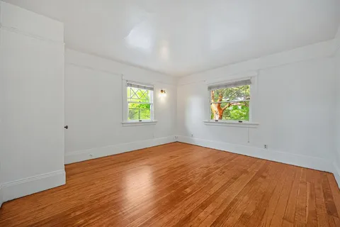 a view of a livingroom with wooden floor and windows