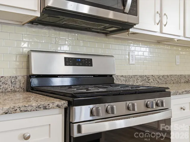 a stove top oven sitting inside of a kitchen