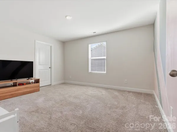 an empty room with windows flat screen tv and windows