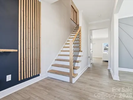 a view of a hallway with wooden floor and entryway