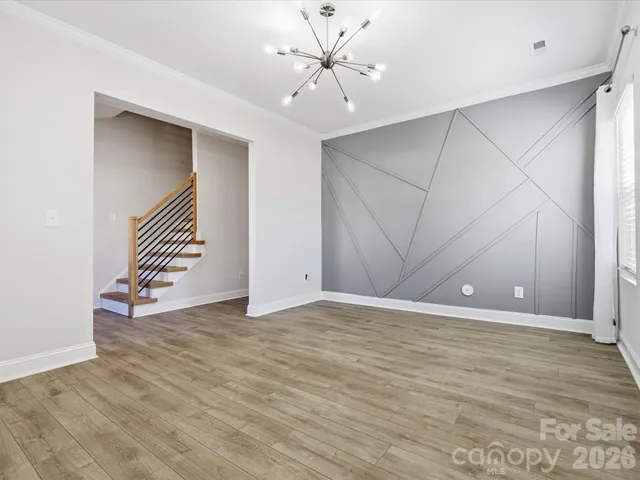 a view of an empty room with window and a ceiling fan