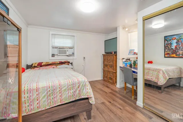 a bedroom with a bed and wooden floor