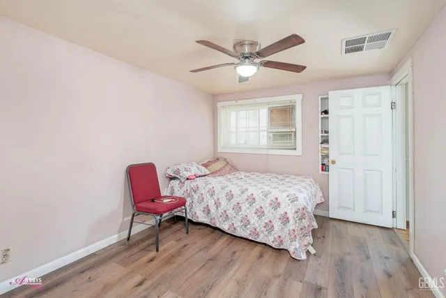 a bedroom with a bed a chair and a potted plant