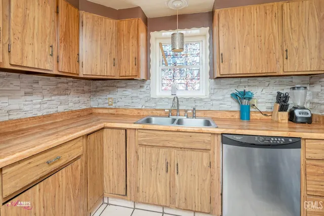 a kitchen with stainless steel appliances granite countertop a sink and cabinets with wooden floor