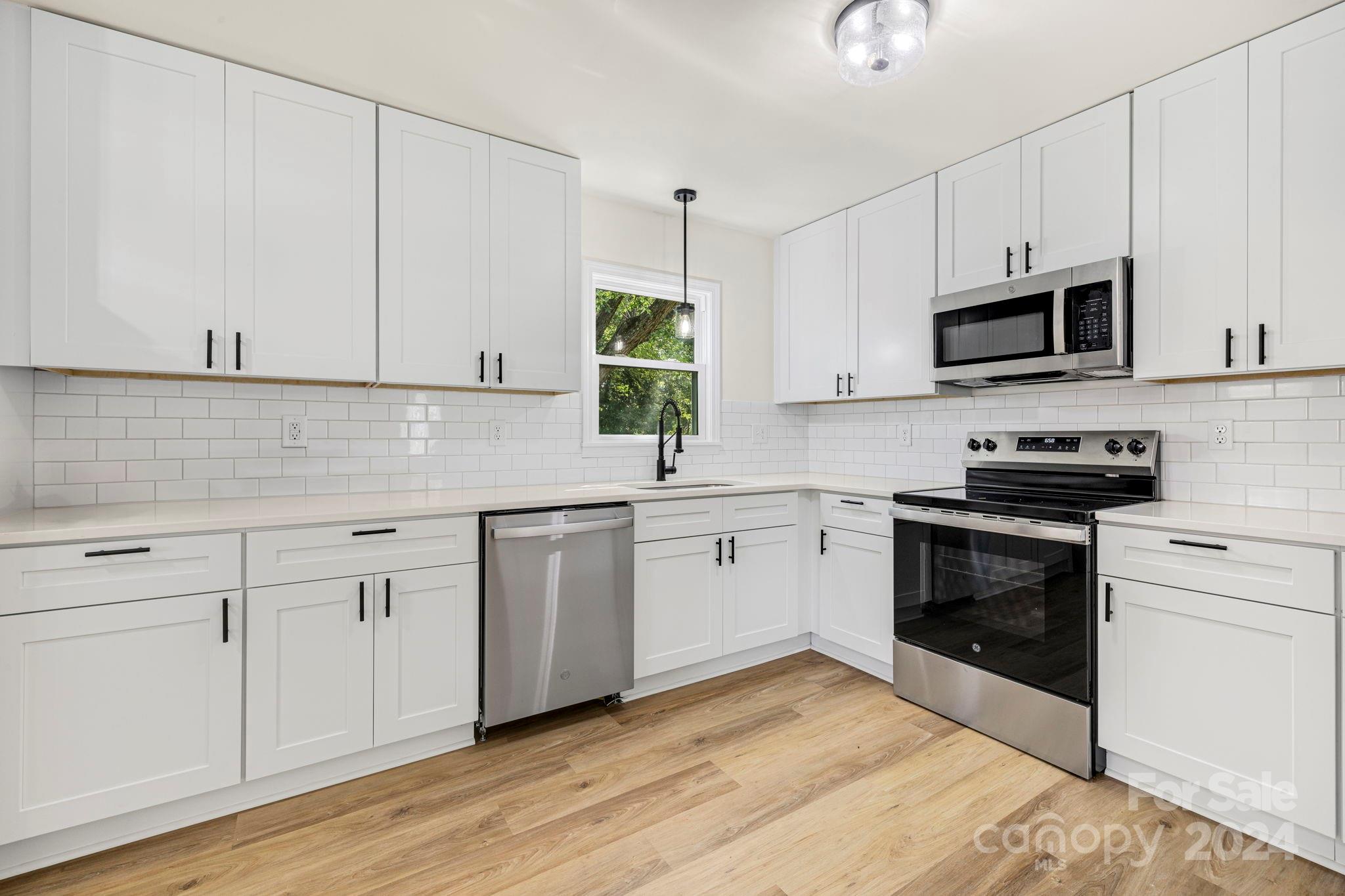 815 Poors Ford Road Rutherfordton, NC 28139 - Photo 11 of 30 a kitchen with stainless steel appliances white cabinets and a stove a sink