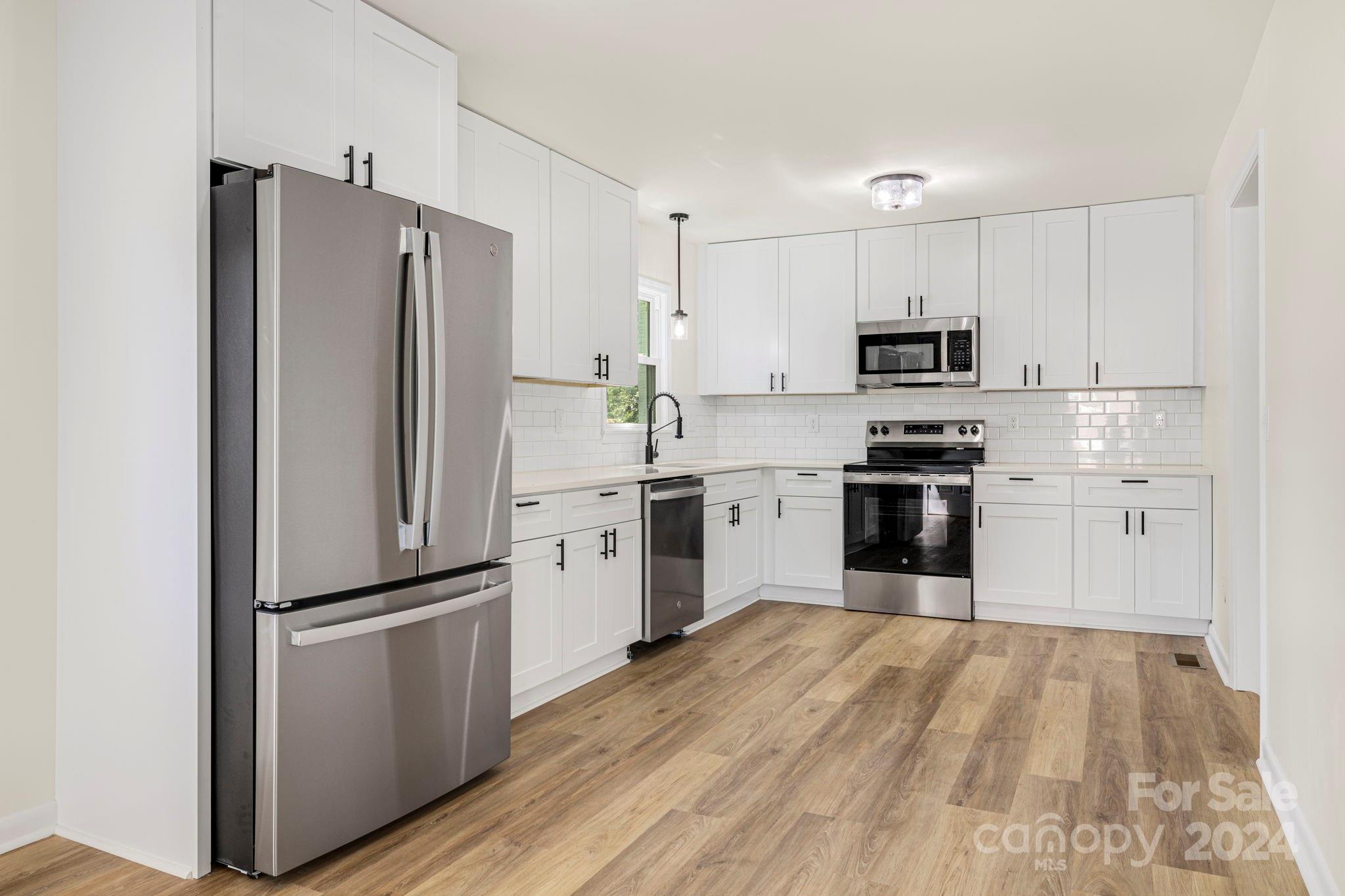 815 Poors Ford Road Rutherfordton, NC 28139 - Photo 12 of 30 a kitchen with white cabinets stainless steel appliances and a refrigerator