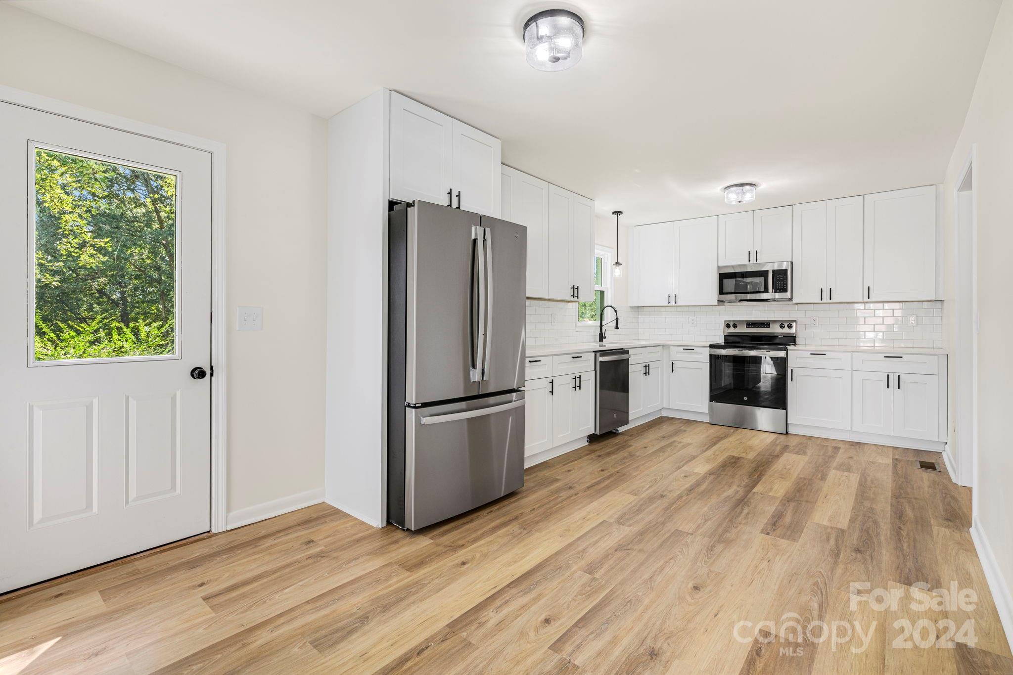 815 Poors Ford Road Rutherfordton, NC 28139 - Photo 14 of 30 a kitchen with white cabinets and stainless steel appliances