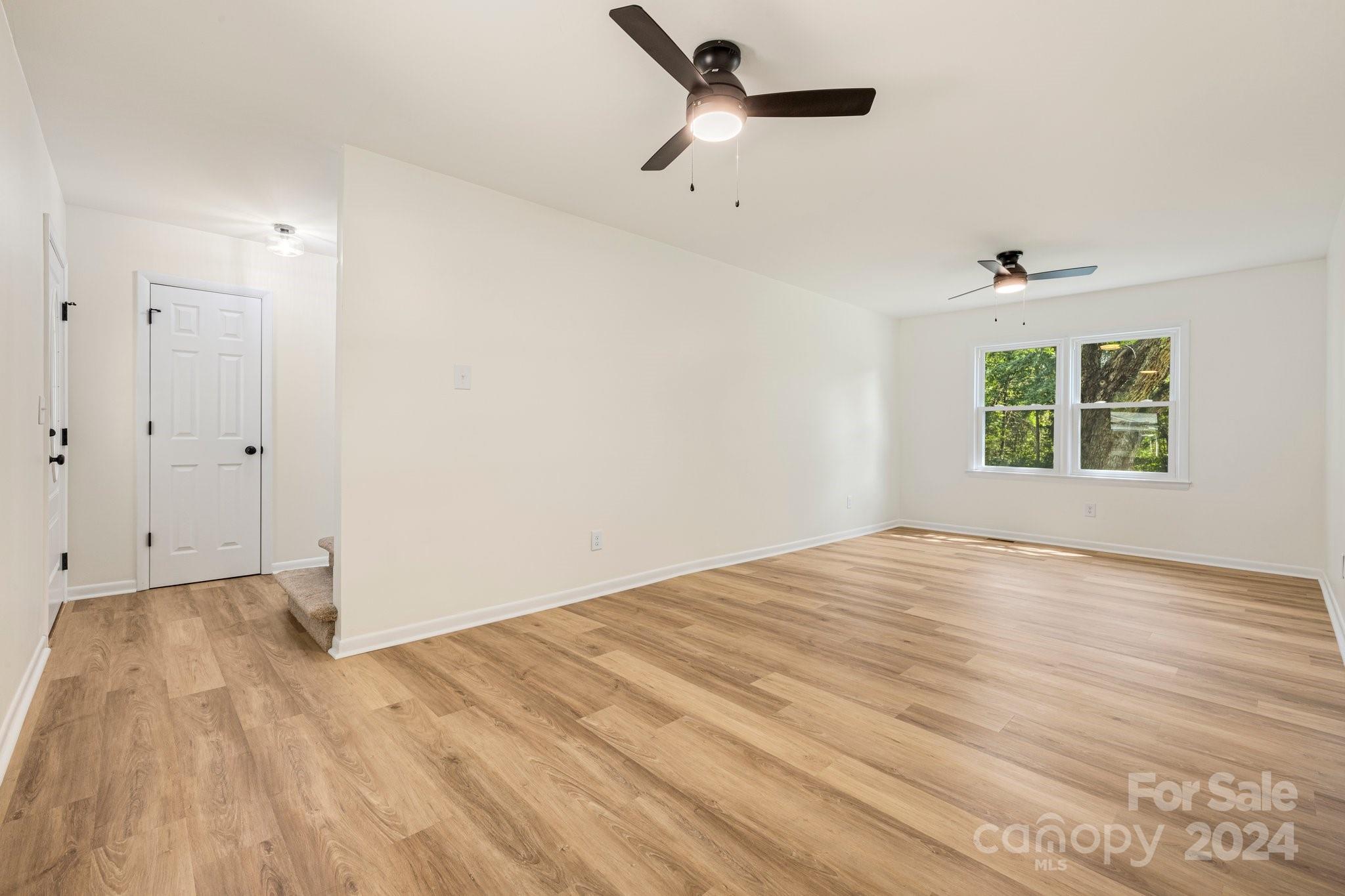 815 Poors Ford Road Rutherfordton, NC 28139 - Photo 3 of 30 a view of empty room with wooden floor and fan