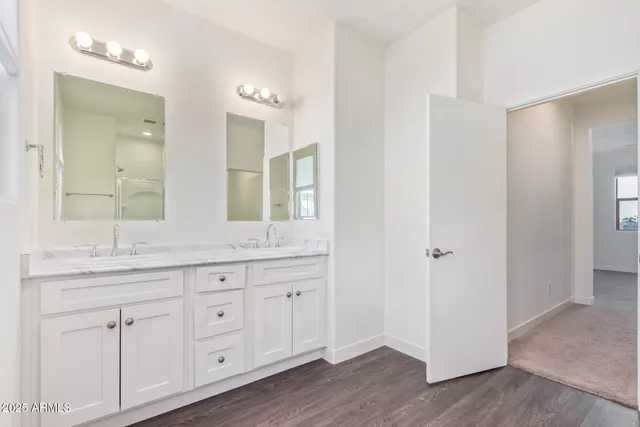 a bathroom with double vanity sink a window and a mirror