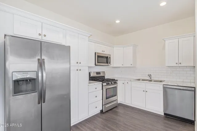 a view of a kitchen with wooden floor and a sink