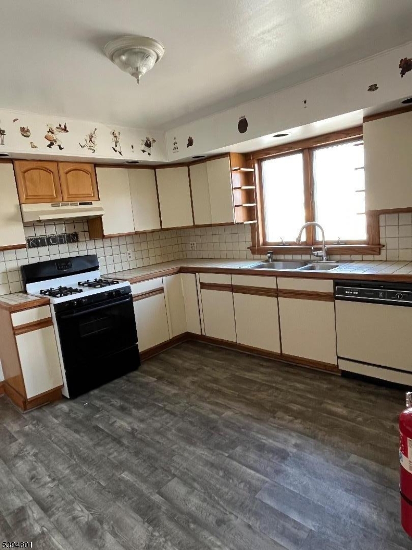 469 Crooks Avenue Clifton, NJ 07011 - Photo 11 of 12 a kitchen with stainless steel appliances granite countertop a stove a sink and a microwave