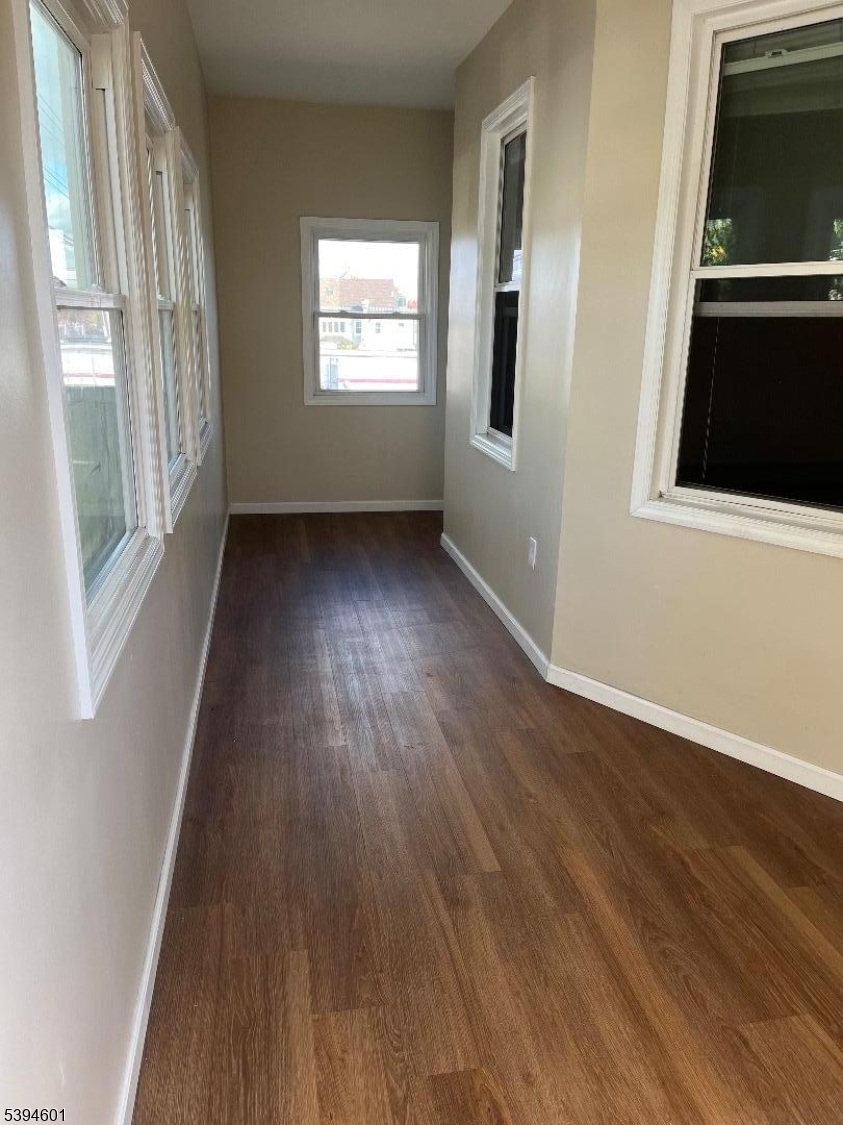469 Crooks Avenue Clifton, NJ 07011 - Photo 4 of 12 a view of an empty room with wooden floor and a window