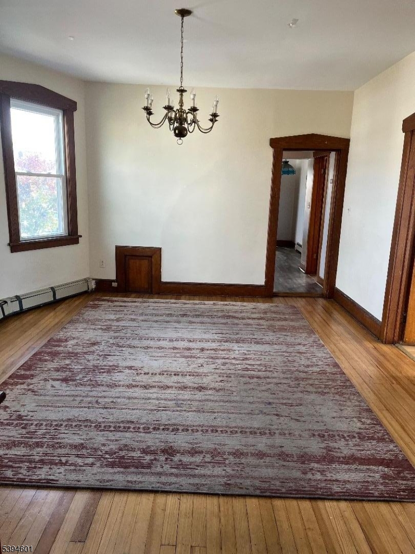 469 Crooks Avenue Clifton, NJ 07011 - Photo 7 of 12 a view of an empty room with window and wooden floor