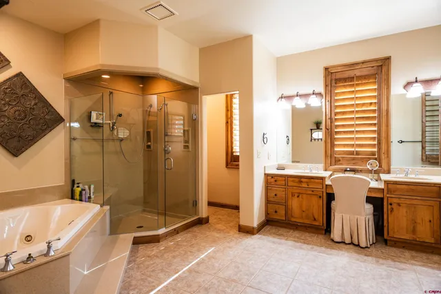 a bathroom with a tub a sink and a large mirror