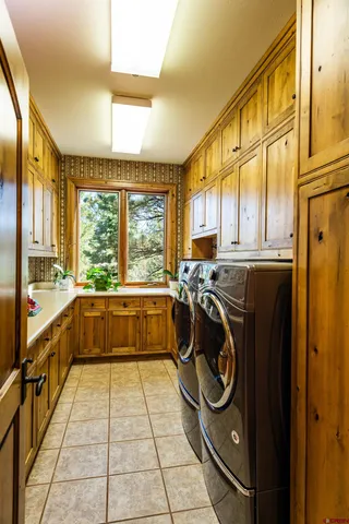 a bathroom with a tub a sink and a large mirror next to a window