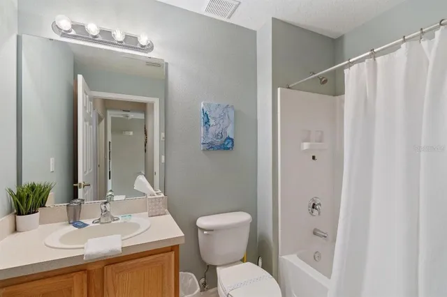 a bathroom with a sink vanity mirror and toilet