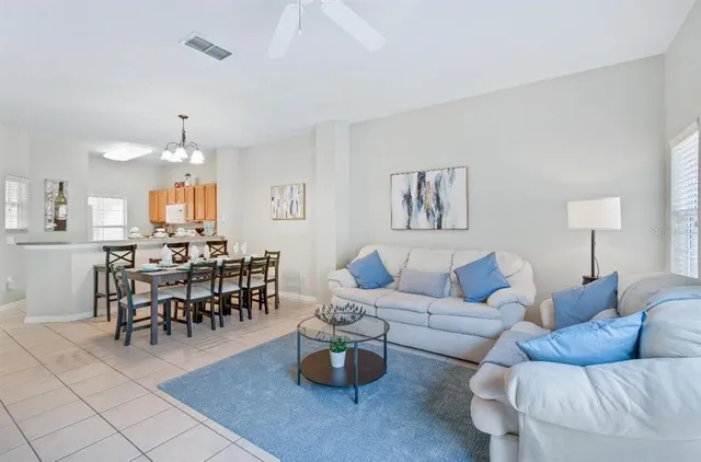 a living room with couches and a dining table with kitchen view