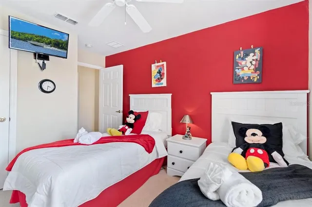 a bedroom with a bed a dresser and painting on the wall