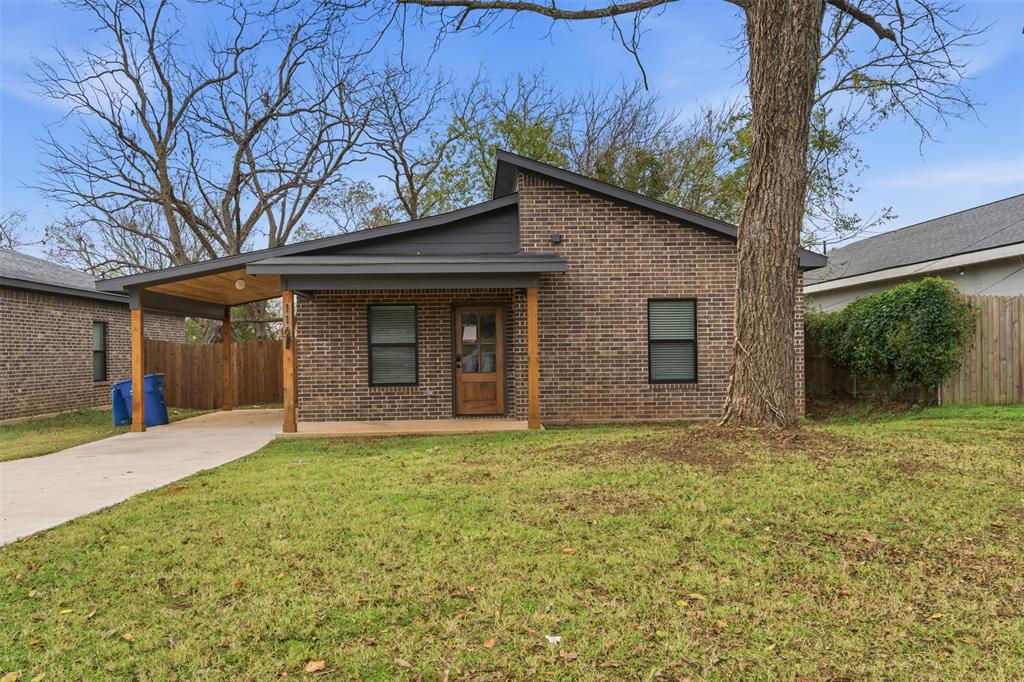 Mid-century inspired home with brick siding, a patio, concrete driveway, and a carport