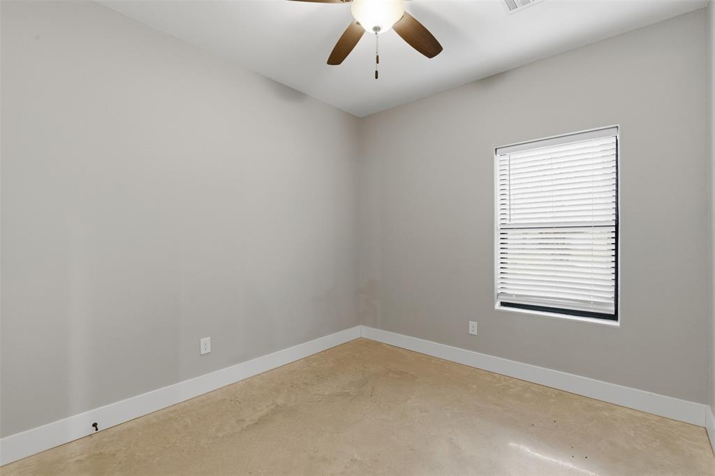 116 Harrison Street Denison, TX 75021 - Photo 21 of 25 Empty room with a ceiling fan and concrete floors