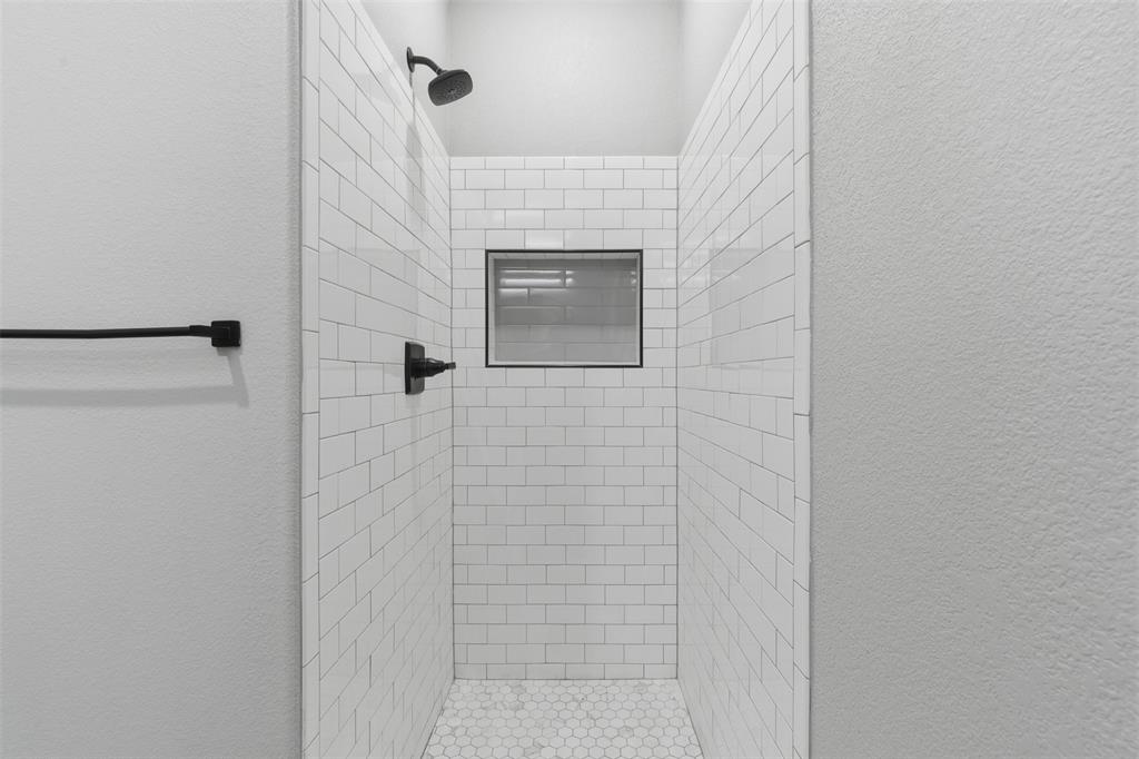 116 Harrison Street Denison, TX 75021 - Photo 23 of 25 Bathroom featuring a textured wall and a shower stall