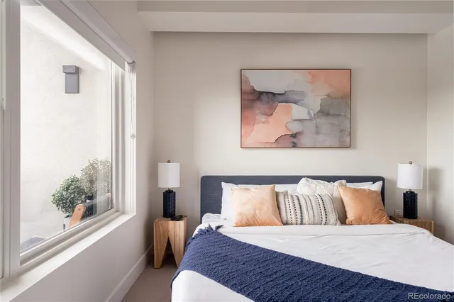 a bedroom with a bed and a painting on the wall
