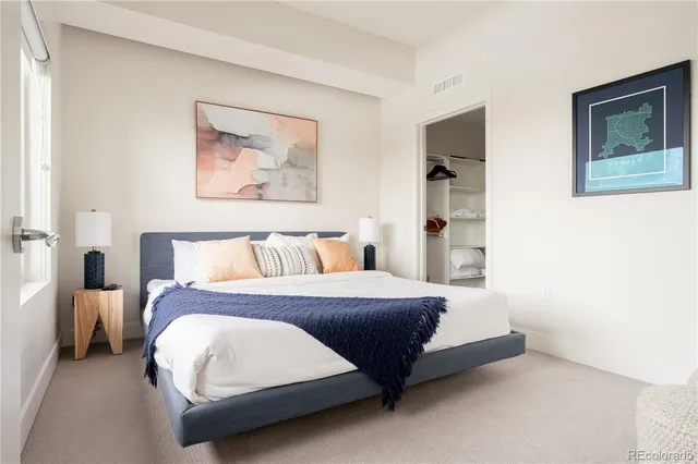 a bedroom with a bed and a painting on the wall