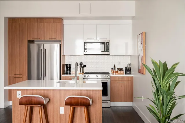 a kitchen with stainless steel appliances granite countertop a refrigerator a stove a sink a counter space and cabinets