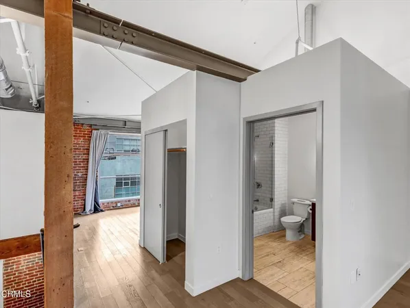 a very nice looking room with wooden floor and a bathroom