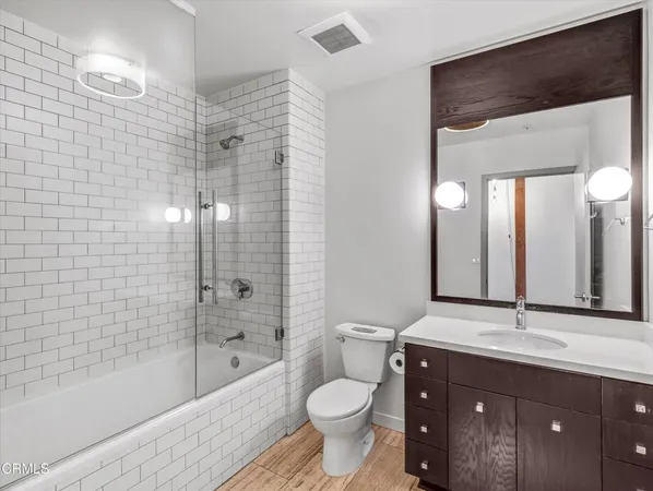 a bathroom with a granite countertop toilet sink and mirror