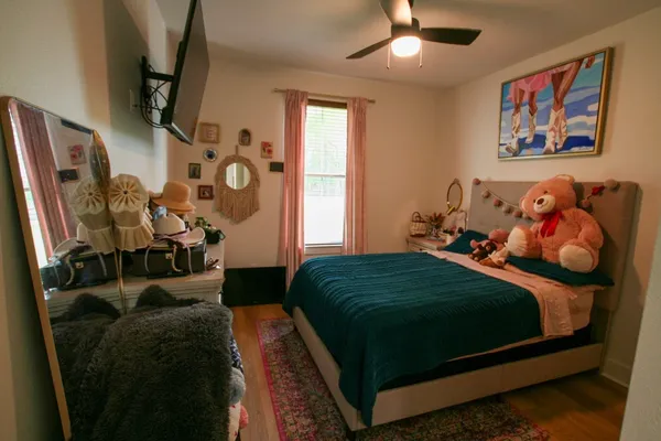a bedroom with a bed dresser and window