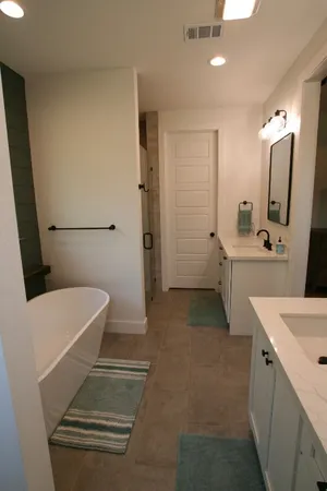 a bathroom with a sink a toilet a mirror and shower
