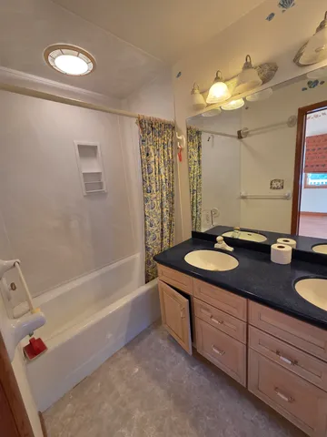 a bathroom with a granite countertop sink a mirror and a bathtub