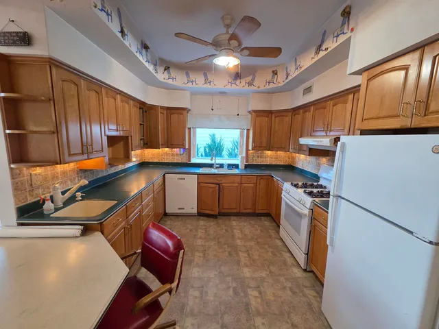 a kitchen with granite countertop a sink stainless steel appliances and cabinets
