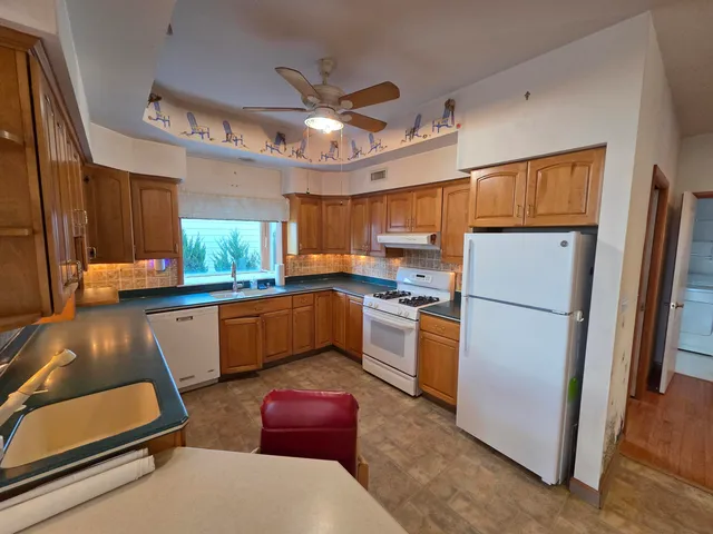 a kitchen with a refrigerator a counter space and a sink