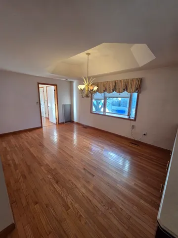 an empty room with wooden floor and window
