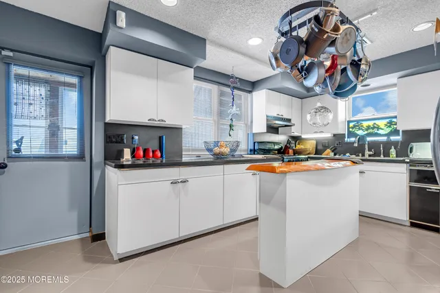 a kitchen with stainless steel appliances granite countertop a sink dishwasher and a refrigerator with wooden floor