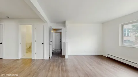 a view of a room with wooden floor and window