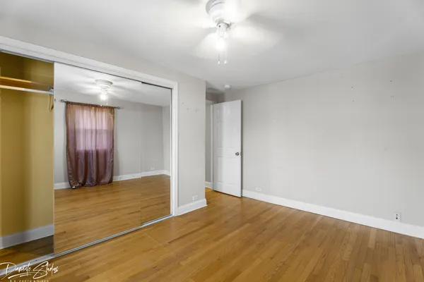 a view of empty room with wooden floor