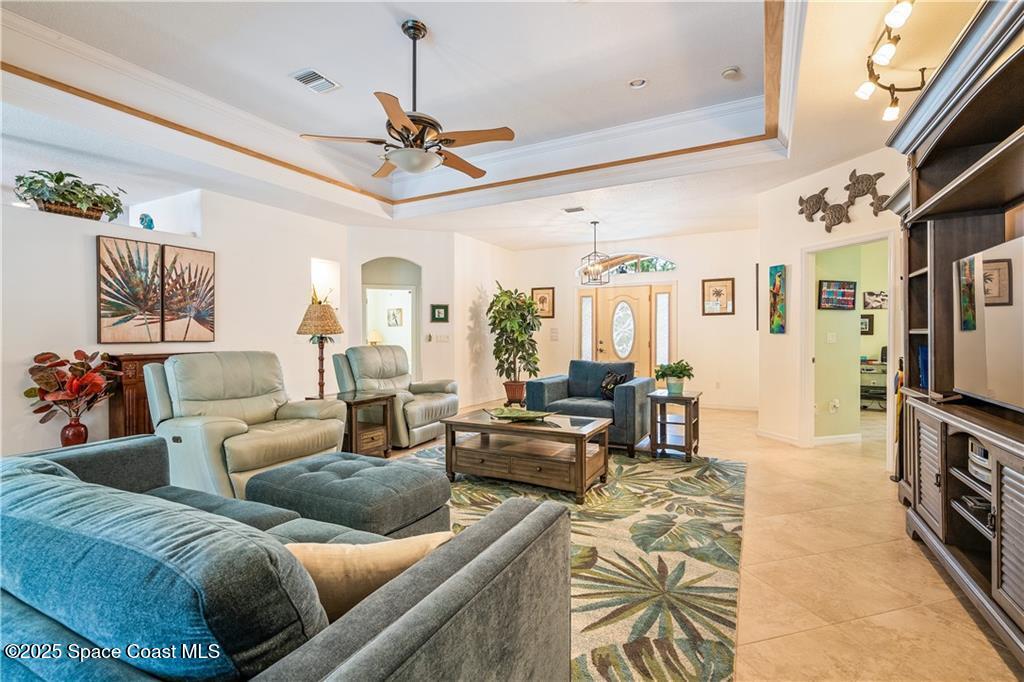 3975 Pepper Tree Street Grant, FL 32949 - Photo 14 of 36 a living room with furniture a chandelier and a flat screen tv
