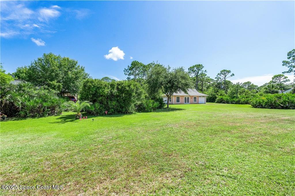 3975 Pepper Tree Street Grant, FL 32949 - Photo 32 of 36 a view of a garden with a building in the background