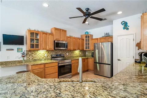 a kitchen with stainless steel appliances granite countertop a refrigerator a stove and a sink