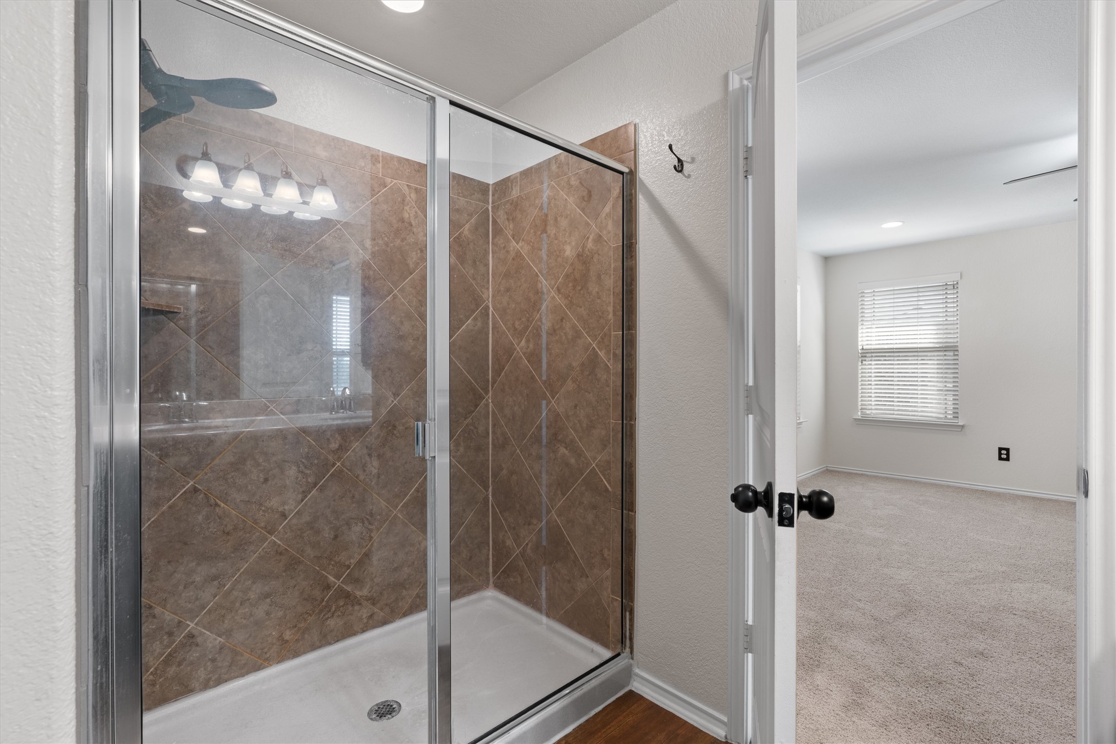 804 Water Hyacinth Loop Leander, TX 78641 - Photo 20 of 37 a bathroom with a glass shower door and a mirror