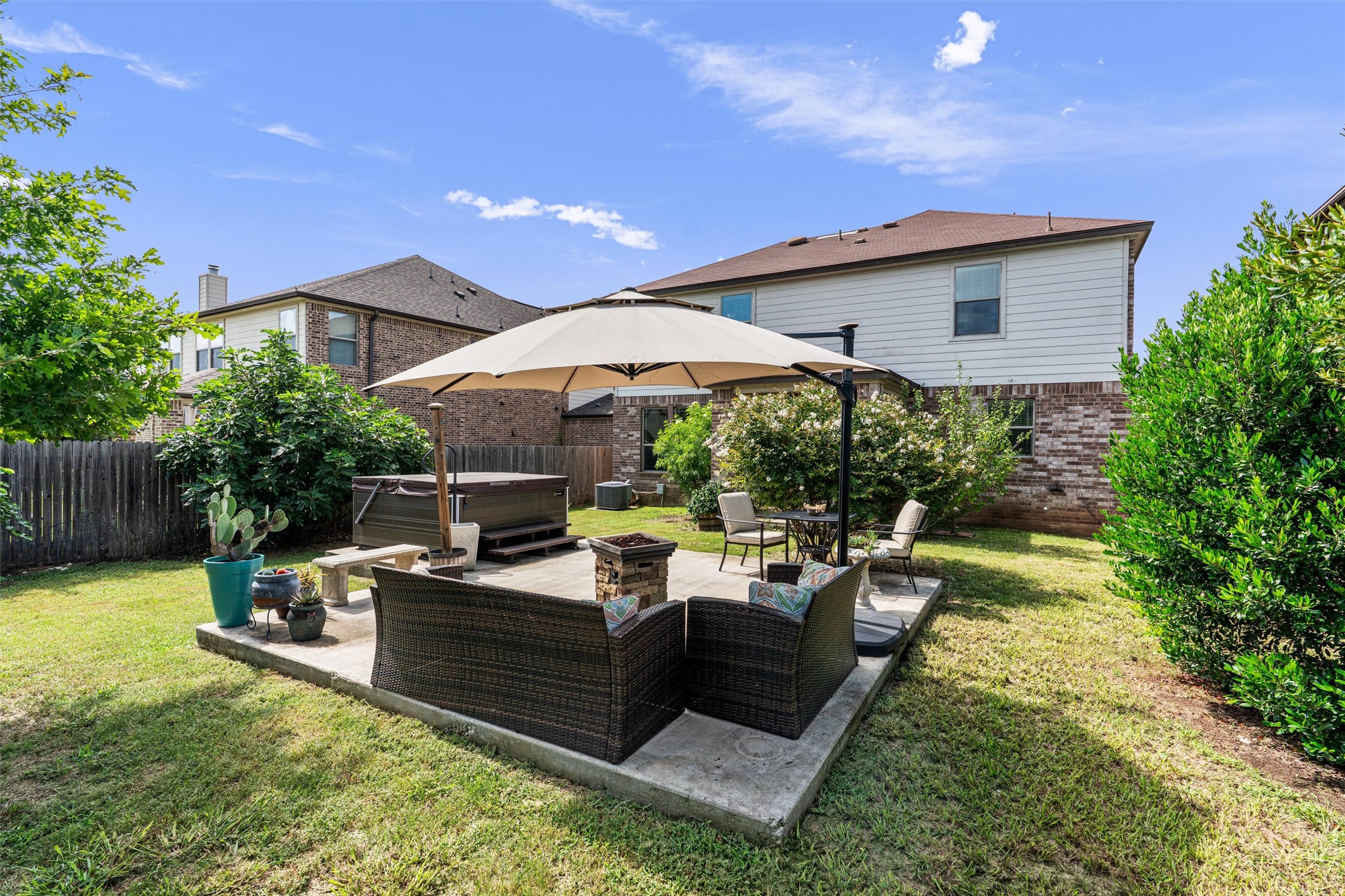 804 Water Hyacinth Loop Leander, TX 78641 - Photo 32 of 37 a view of a patio with table and chairs under an umbrella next to a house