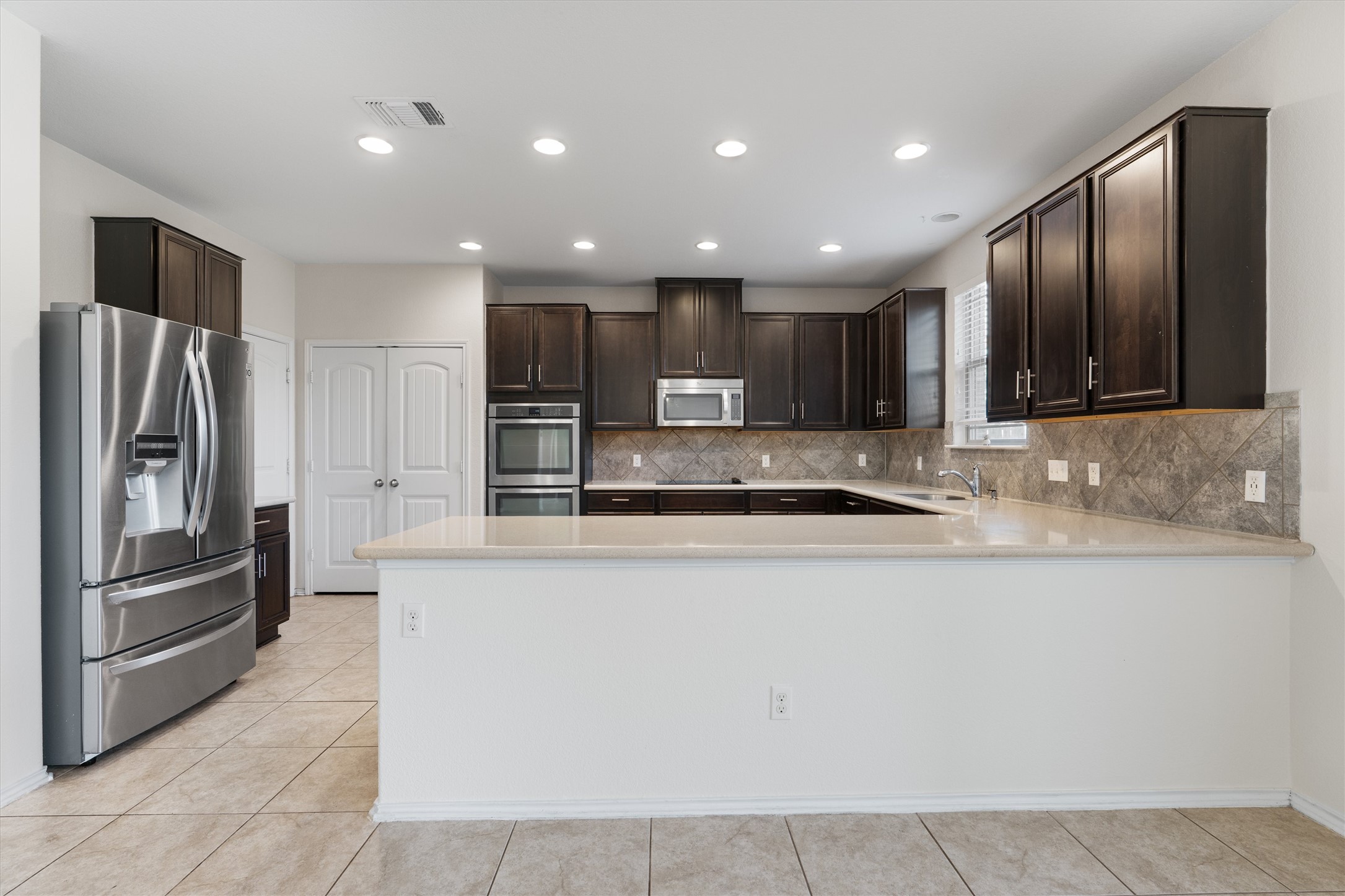 804 Water Hyacinth Loop Leander, TX 78641 - Photo 9 of 37 a large kitchen with stainless steel appliances and a refrigerator