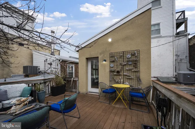 a balcony with wooden floor table and chairs